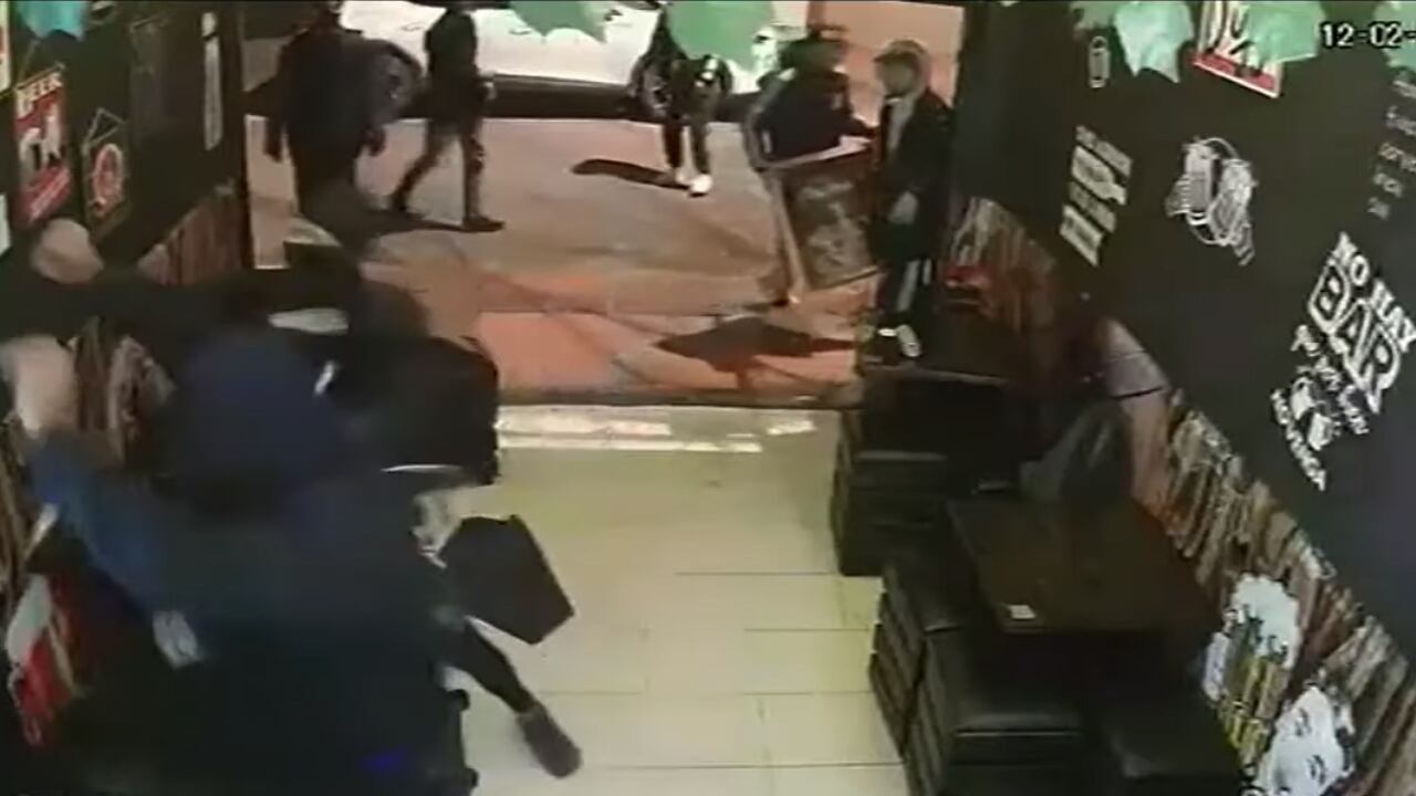 Uno de los sujetos golpeó con un hacha la puerta del baño del bar