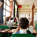 School children in uniforms in class with tablets