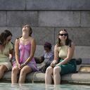 Un grupo de mujeres se refresca sumergiendo sus pies en la fuente de Trafalgar Square, en el centro de Londres, el 18 de julio de 2022 mientras el país experimenta una ola de calor extremo (foto de Niklas HALLE'N / AFP)