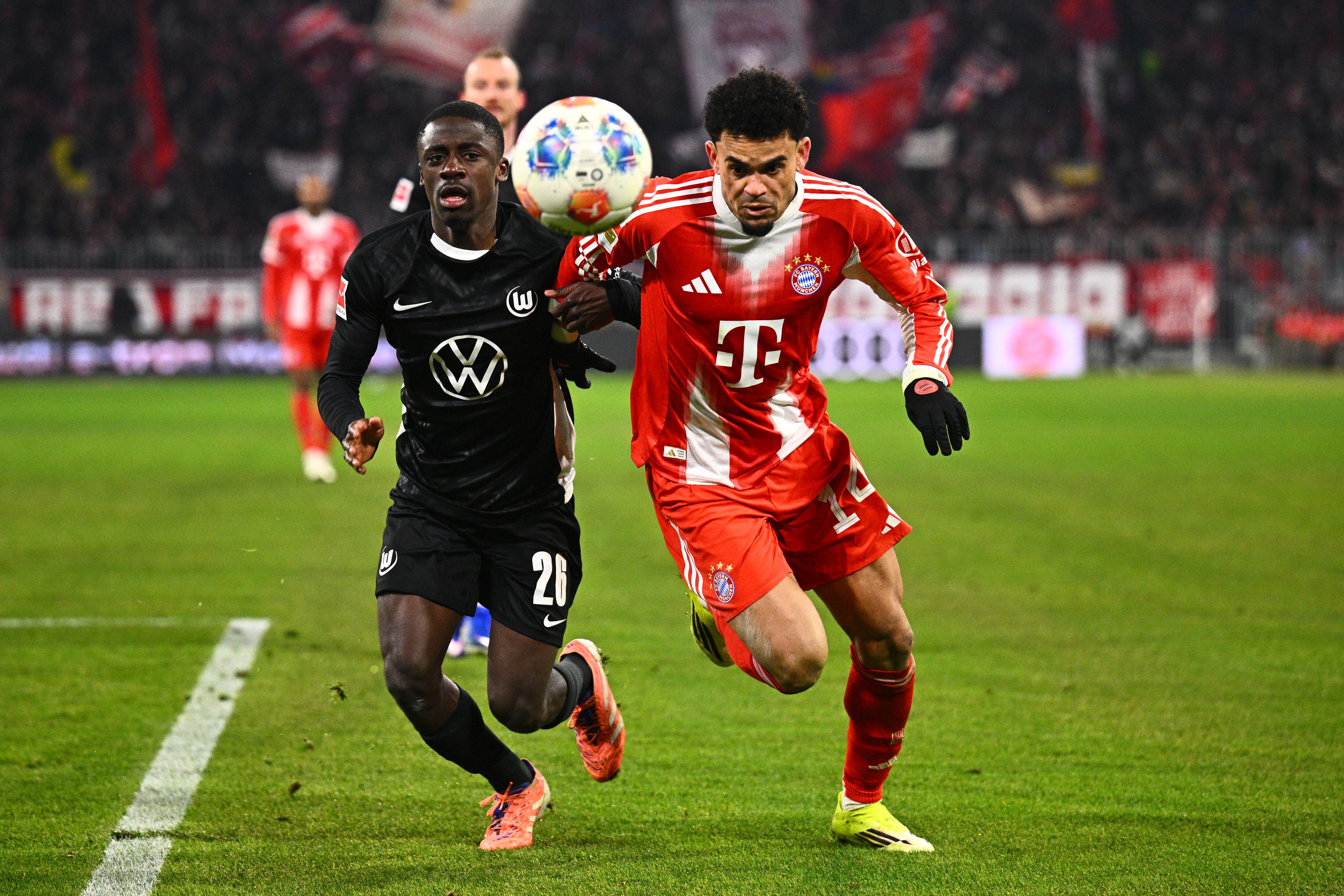Wolfsburg's Saël Kumbedi and Munich's Luis Diaz, right, in action during the Bundesliga soccer match between Bayern Munich and VfL Wolfsburg in Munich, Germany, Sunday Jan. 11, 2026. (Tom Weller/dpa via AP)