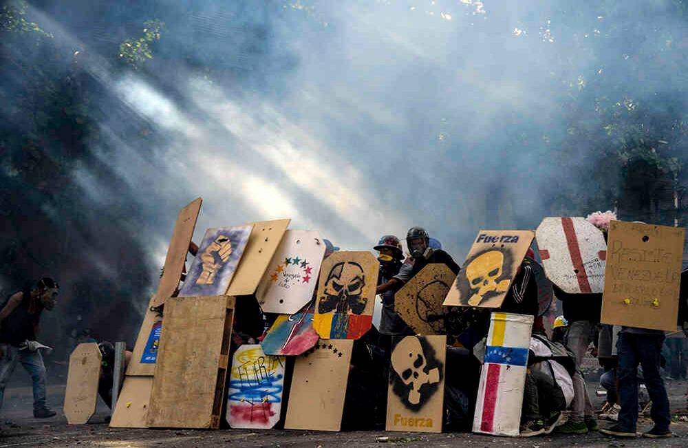 Con escudos de madera y metal, pintados con imágenes y mensajes contra el presidente Nicolás Maduro, un grupo de jóvenes ocupa la vanguardia de las manifestaciones en Caracas. Usan máscaras antigás, cascos y capuchas y los llaman "los escuderos".