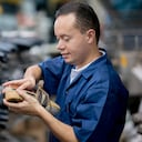 Zapatero latinoamericano trabajando en una fábrica en la línea de producción - conceptos de fabricación