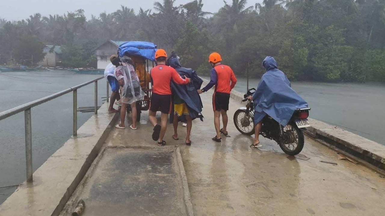 En esta imagen proporcionada por la Guardia Costera de Filipinas, rescatistas evacúan gente a zonas más seguras en la provincia de Quezon, en el este de Filipinas, mientras el tifón Fung-wong se aproxima al país.