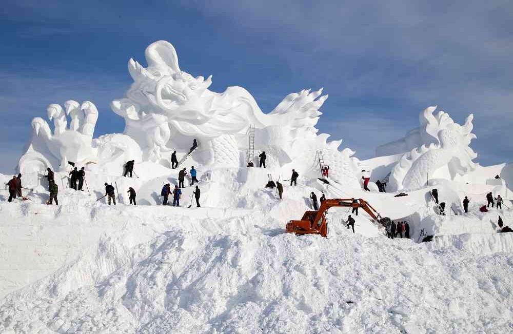 Esta foto tomada el 23 de diciembre de 2017 muestra artistas que trabajan en el sitio de construcción de una escultura de nieve de 80 metros de largo para el festival de esquí Vasaloppet China en Changchun, en la provincia nororiental de Jilin, en China.