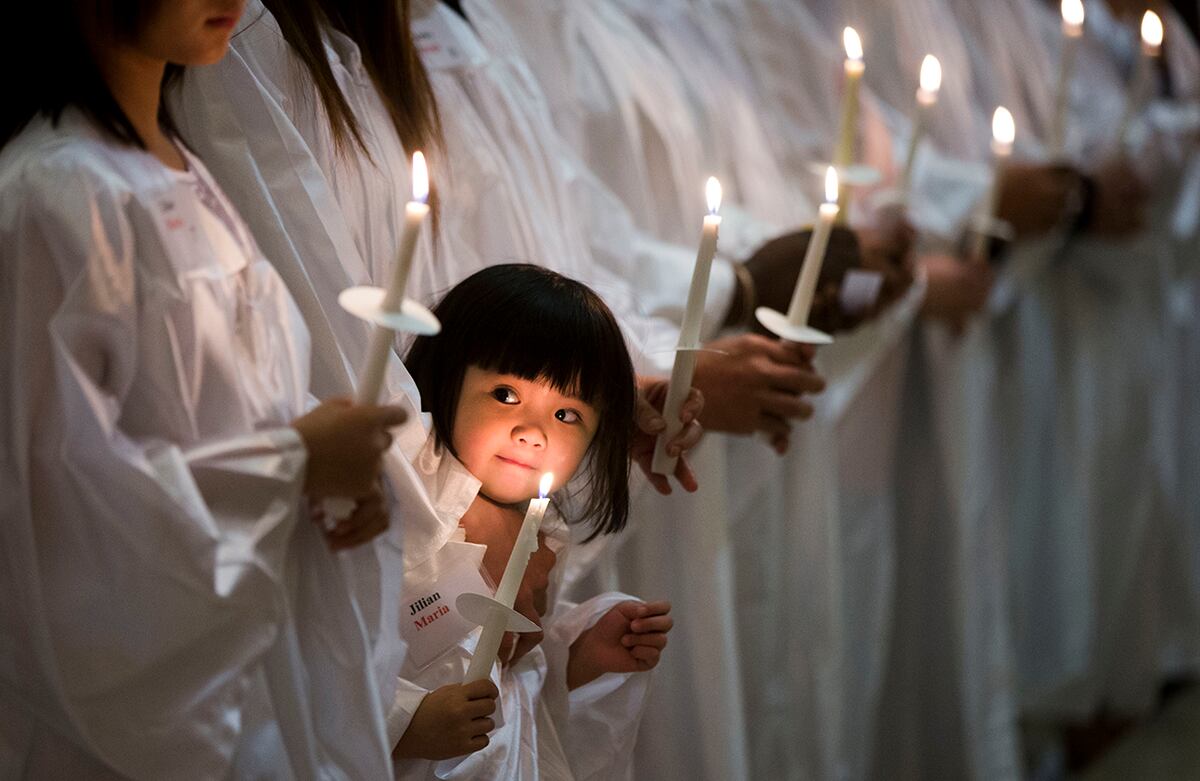 Una niña de tres años de nacionalidad vietnamita y estadounidense espera para ser bautizada en la Iglesia Católica de Santa Helena, en Filadelfia, Estados Unidos. (AP)