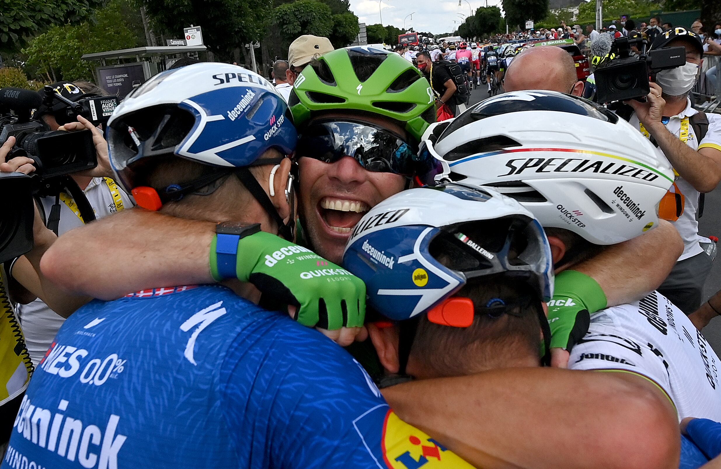 Stage winner Team Deceuninck Quickstep's Mark Cavendish of Great Britain celebrates with his teammates after winning the 6th stage of the 108th edition of the Tour de France cycling race, 160 km between Tours and Chateauroux, on July 01, 2021. (Photo by - / POOL / AFP)