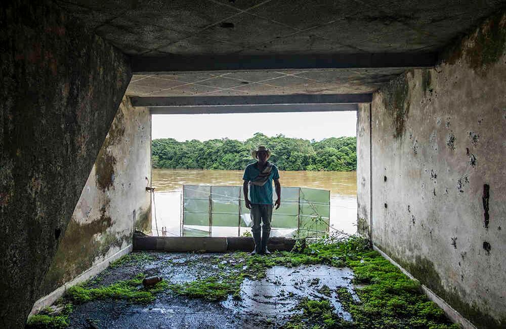 José Alfredo Carlosana Fernández, de 39 años, posa frente a su antiguo hogar. Su casa servía como juguetería en el primer piso, restaurante en el segundo y hogar en el tercero. Fue desplazado por la violencia en 2004. Hace 7 años volvió a Peñas Coloradas a una finca de su padre, donde vive y trabaja.