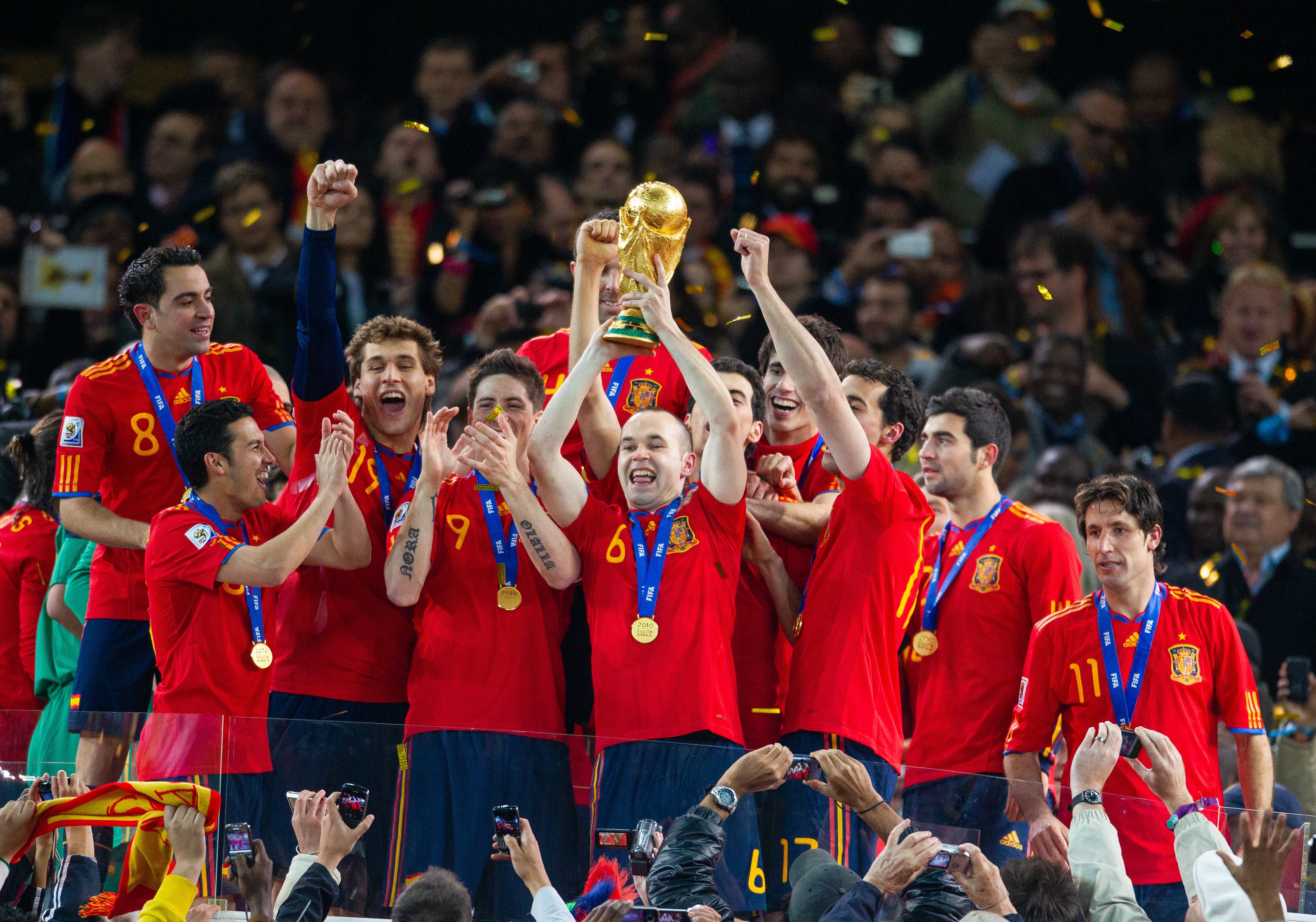 JOHANNESBURG, SOUTH AFRICA - JULY 11: Andreas Iniesta of Spain and the goal scorer celebrates with the trophy and and the Spanish team after victory in the World Cup Final match between Spain (1) and Netherlands (0) at the FNB Stadium on July 11, 2010 in Johannesburg, South Africa (Photo by Simon Bruty/Anychance/Getty Images)