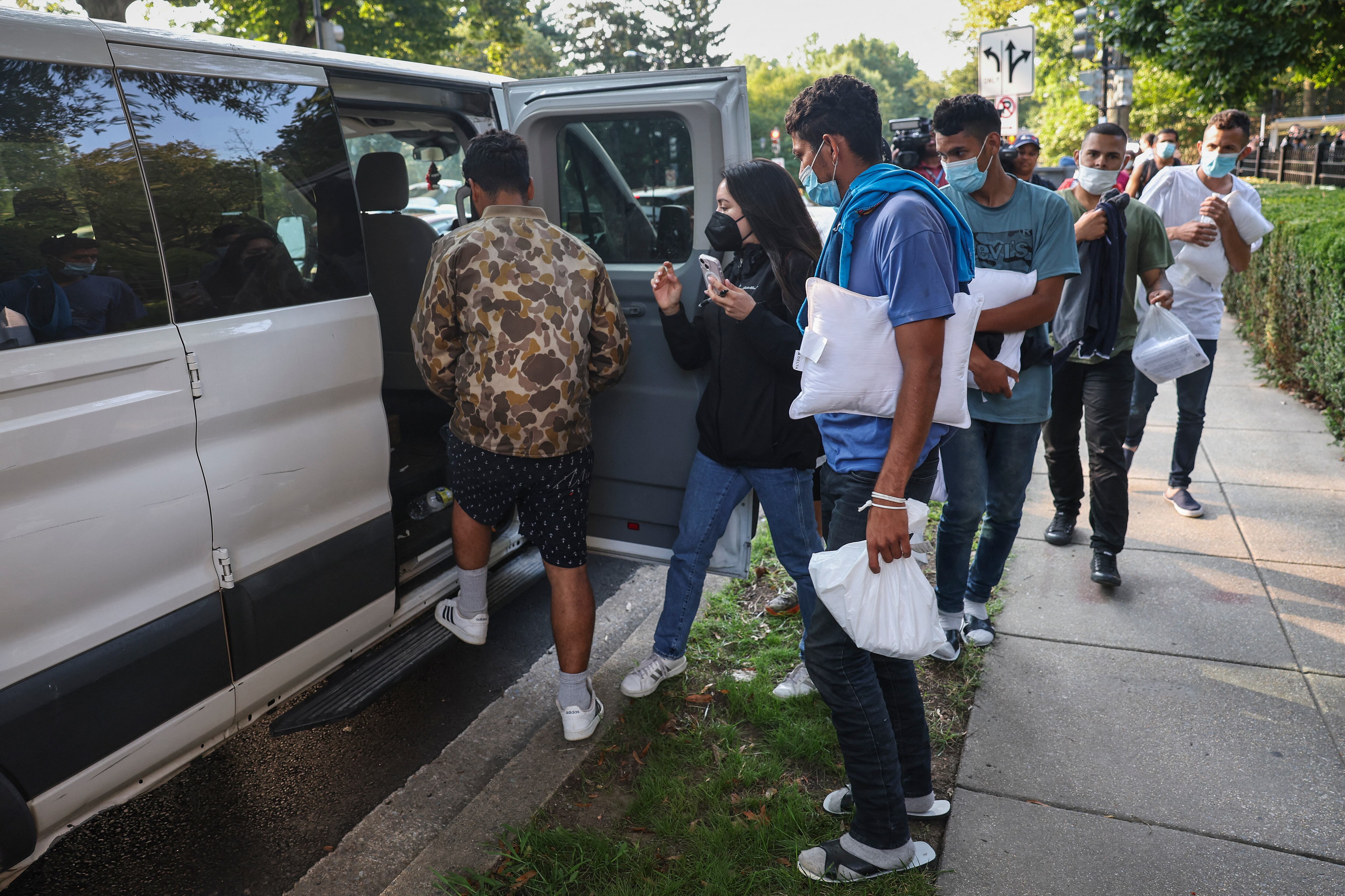 Migrantes de Venezuela, que abordaron un autobús en Texas, esperan ser transportados a una iglesia local por voluntarios después de ser dejados frente a la residencia de la vicepresidenta de EE. UU. Kamala Harris, en el Observatorio Naval en Washington, DC, el 15 de septiembre de 2022. - Desde abril, el gobernador de Texas, Greg Abbott, ordenó autobuses para transportar a miles de migrantes de Texas a Washington, DC, la ciudad de Nueva York y Chicago para resaltar las críticas a la política fronteriza del presidente estadounidense Joe Biden. (Foto de Stefani Reynolds / AFP)