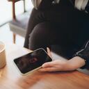 Woman holding a smartphone computer that needs charging