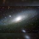 La galaxia de Andrómeda, situada a unos dos millones doscientos mil años luz del Sol. Si alguien desde allí mirara a la Tierra ahora, vería un planeta por el que dan los primeros pasos las especies precursoras del género Homo. Wikimedia Commons / Adam Evans, CC BY-SA publicada por The Conversation