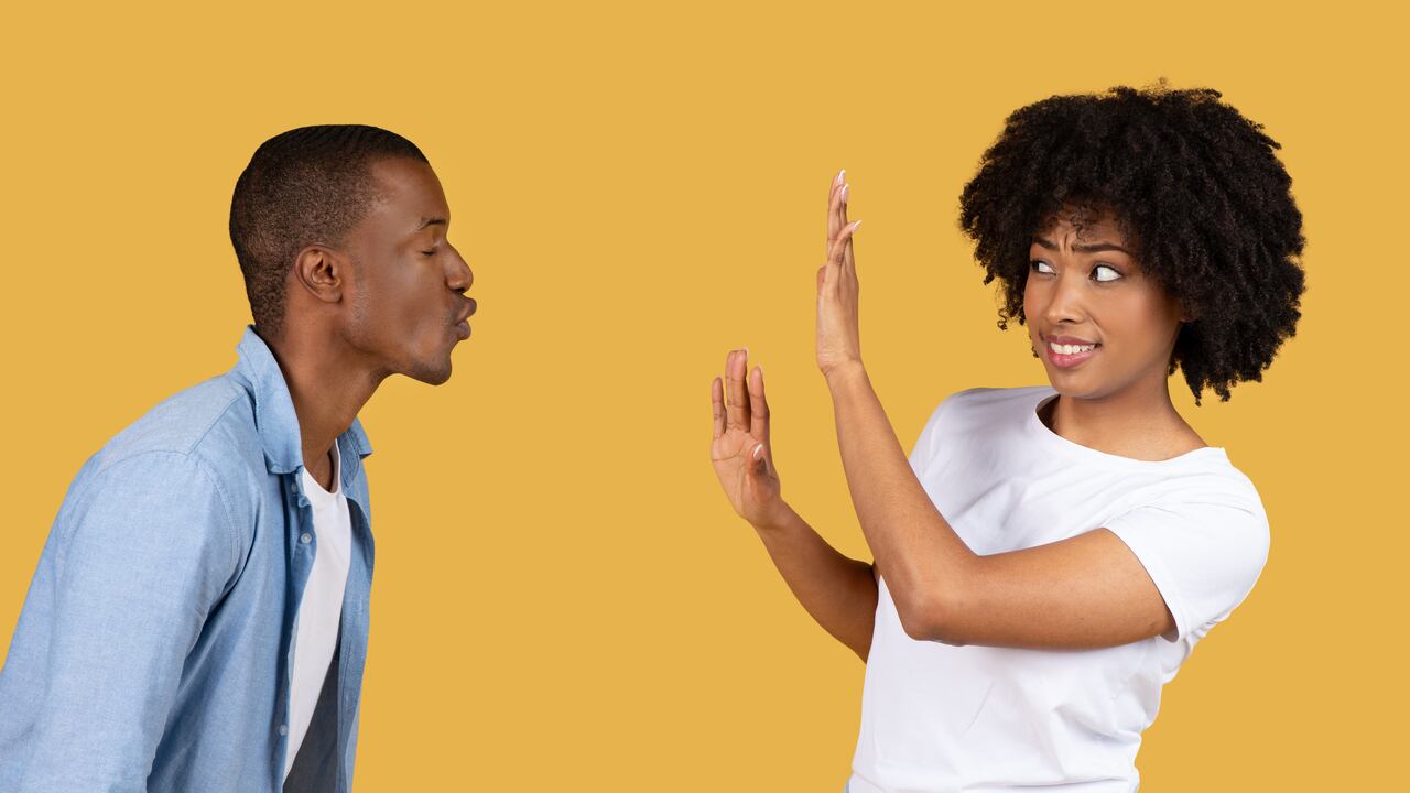 Mujer rechazando beso juguetón de un hombre
