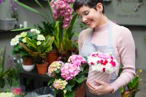 Young happy woman working in the flower shop.