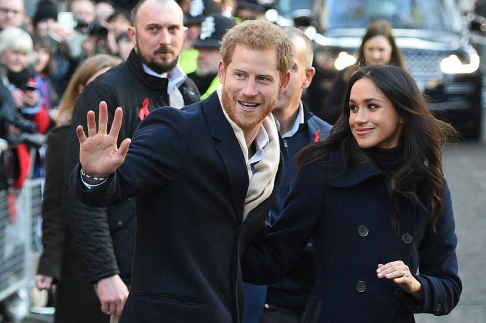 El príncipe Harry y su ahora esposa, la actriz estadounidense Meghan Markle, saludan a los amantes de la buena marcha cuando llegan a Nottingham Contemporary en Nottingham, en el centro de Inglaterra, el 1 de diciembre de 2017 para celebrar una feria de caridad del Terrence Higgins Trust World AIDS Day. / AFP PHOTO / Oli SCARFF