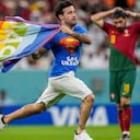 A pitch invader runs across the field with a rainbow flag during the World Cup group H soccer match between Portugal and Uruguay, at the Lusail Stadium in Lusail, Qatar, Monday, Nov. 28, 2022. (AP Photo/Abbie Parr)