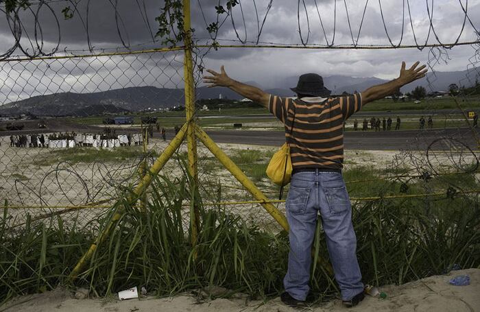 Un manifestante expresa su emoción desde lejos en el aeropuerto..