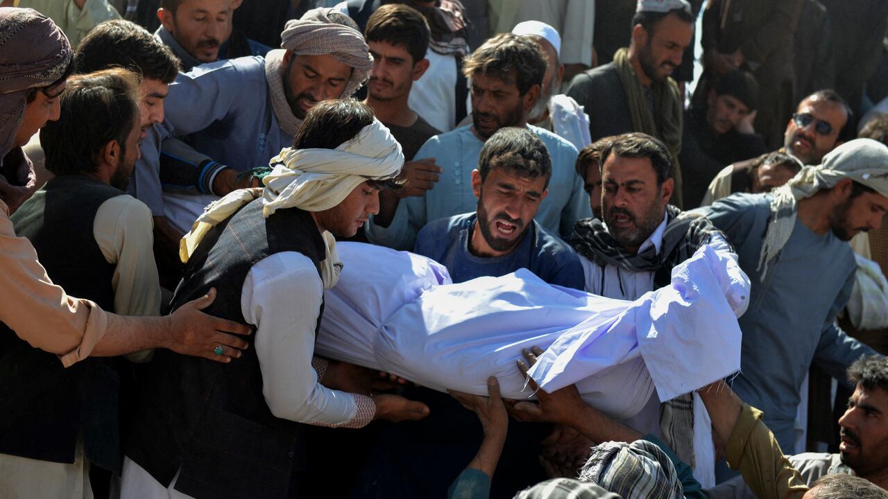 Los familiares se preparan para depositar en una tumba el cuerpo de una víctima.
