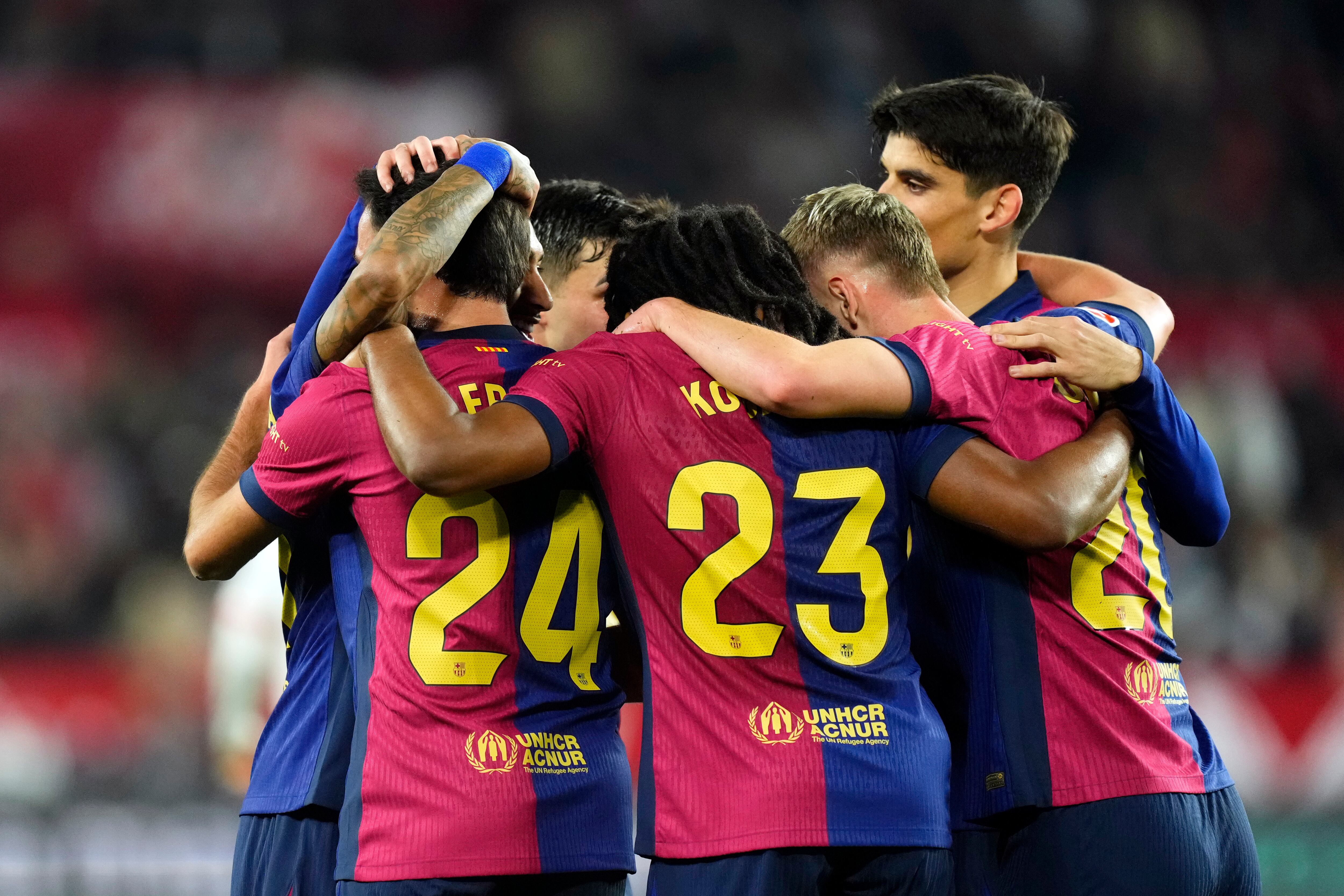 Barcelona's Eric Garcia, foreground left, celebrates with his teammates after scoring his side's fourth goal during a Spanish La Liga soccer match between Sevilla and FC Barcelona at the Ramon Sanchez Pizjuan stadium in Seville, Spain, Sunday, Feb. 9, 2025. (AP Photo/Jose Breton)