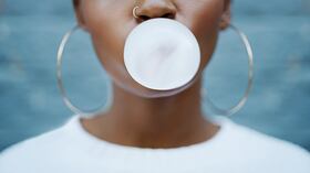 Una persona haciendo un globo con un chicle