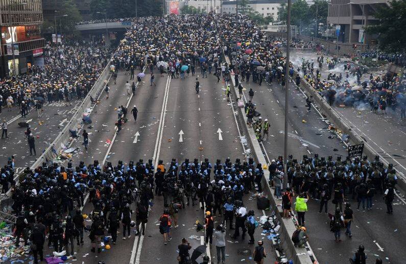12 de junio - En Hong Kong, los manifestantes se enfrentan a la policía después de que lanzaron gas lacrimógeno durante un mitin en protesta contra una controvertida propuesta de ley de extradición a China. FOTO: Anthony WALLACE / AFP