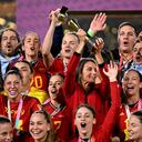 Spain's Queen Letizia (C) lifts the trophy as Spain's players and officials celebrate after winning the Australia and New Zealand 2023 Women's World Cup final football match between Spain and England at Stadium Australia in Sydney on August 20, 2023. (Photo by WILLIAM WEST / AFP)