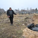 Un hombre señala una fosa común en la ciudad de Bucha, al noroeste de la capital ucraniana, Kiev, el 3 de abril de 2022. - Ucrania y las naciones occidentales acusaron a las tropas rusas de crímenes de guerra después del descubrimiento de fosas comunes y civiles "ejecutados" cerca de Kiev (Photo by Sergei SUPINSKY / AFP)