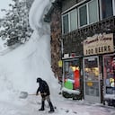 Spike Todd palas frente a su tienda cerca de bancos de nieve acumulados de tormentas anteriores durante otra tormenta de invierno en las montañas de Sierra Nevada el 10 de marzo de 2023 en Mammoth Lakes, California. Todd dijo: 'He vivido aquí 43 años y este se perfila como el invierno más grande que he visto en mi vida'. Las montañas de Sierra Nevada de California están siendo golpeadas por fuertes nevadas en elevaciones más altas, lo que eleva aún más los niveles de la enorme capa de nieve. Las comunidades de las montañas que aún se están recuperando de tormentas anteriores en elevaciones más bajas se enfrentan a posibles inundaciones debido a la escorrentía de lluvia de la décima tormenta fluvial atmosférica del estado. El presidente Joe Biden aprobó la solicitud de emergencia presidencial del gobernador Gavin Newsom en respuesta a las recientes tormentas que afectaron a California. Mario Tama/Getty Images/AFP (Foto de MARIO TAMA/GETTY IMAGES NORTH AMERICA/Getty Images vía AFP)