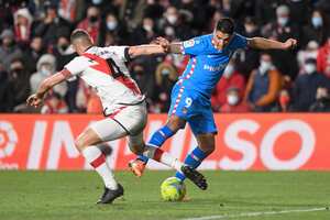 Rayo Vallecano's Spanish midfielder Mario Suarez (L) fights for the ball with Atletico Madrid's Uruguayan forward Luis Suarez during the Spanish League football match between Rayo Vallecano de Madrid and Club Atletico de Madrid at the Vallecas stadium in Madrid on March 19, 2022. (Photo by OSCAR DEL POZO / AFP)