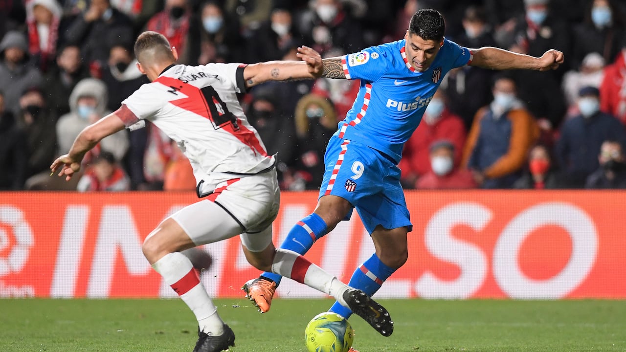 Rayo Vallecano's Spanish midfielder Mario Suarez (L) fights for the ball with Atletico Madrid's Uruguayan forward Luis Suarez during the Spanish League football match between Rayo Vallecano de Madrid and Club Atletico de Madrid at the Vallecas stadium in Madrid on March 19, 2022. (Photo by OSCAR DEL POZO / AFP)
