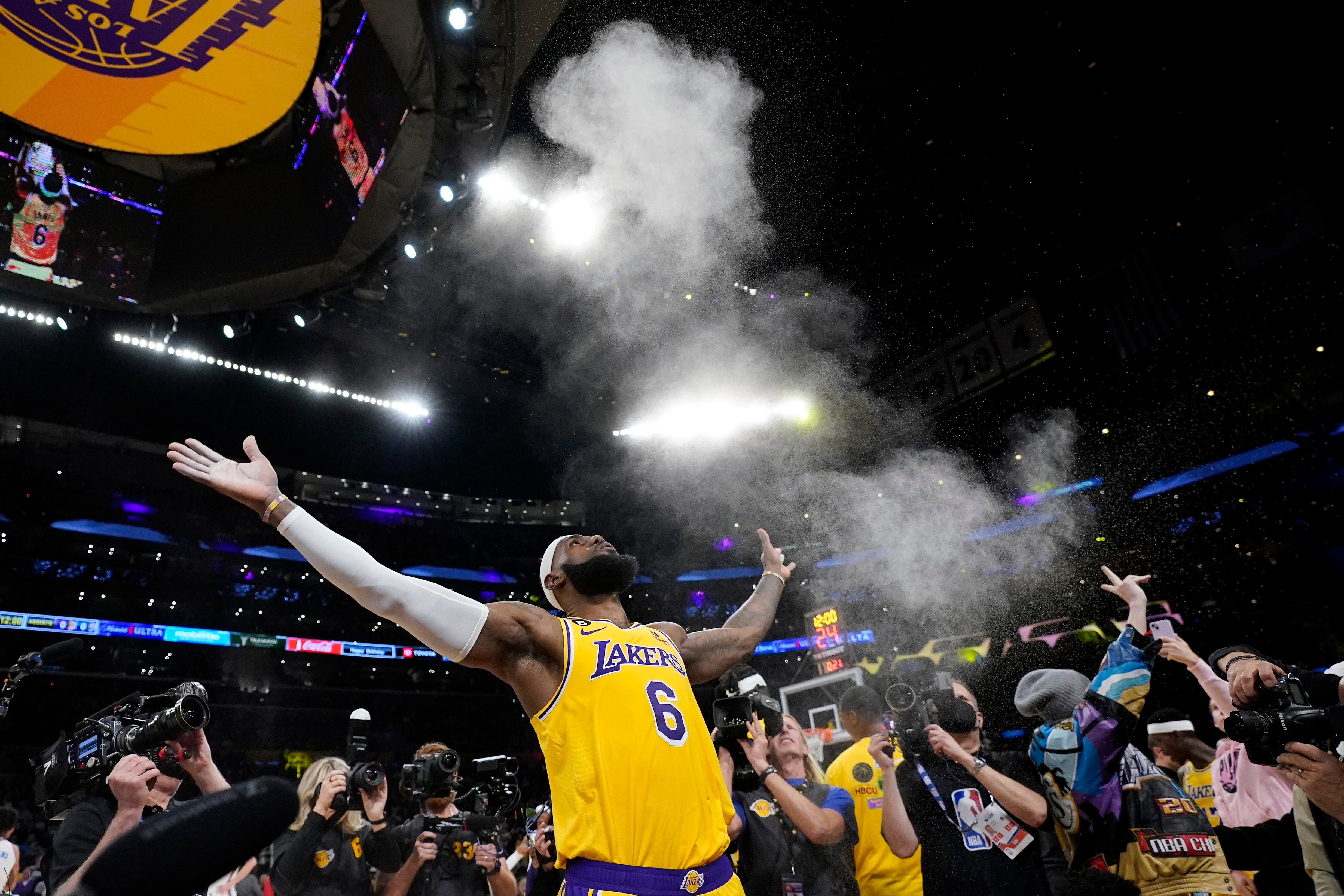 Los Angeles Lakers forward LeBron James tosses powder in the air prior to the team's NBA basketball game against the Oklahoma City Thunder on Tuesday, Feb. 7, 2023, in Los Angeles. (AP Photo/Ashley Landis)
