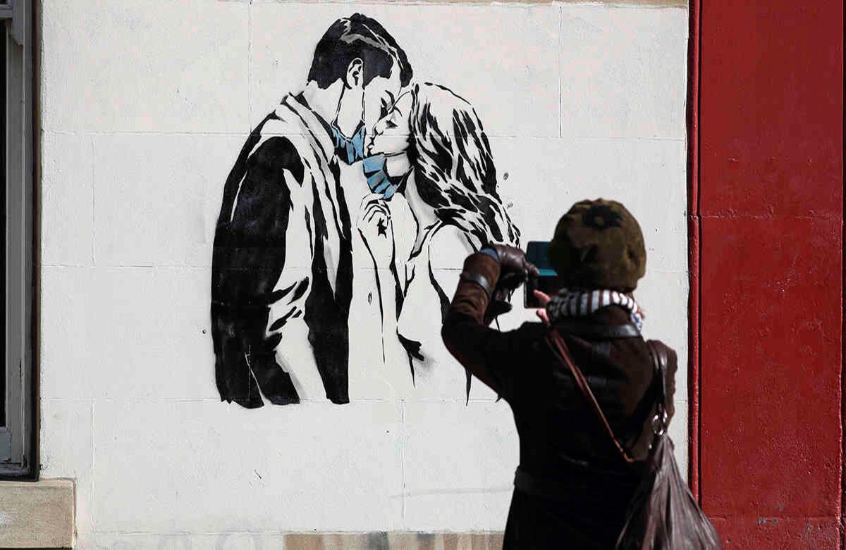 El artista callejero Rebel Bear, Oso Rebelde en español, realizó una obra de arte en una pared en Bank Street en Glasgow, Escocia, el 19 de marzo. La nueva edición del arte callejero de Glasgow captura algunas de las dificultades que ha generado la crisis global del coronavirus. Esta imagen hace una referencia al amor en tiempos de pandemia. Foto: Andrew Milligan / AP.