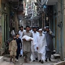 Un hombre carga el cuerpo de un recién nacido que falleció tras un incendio en la sala de maternidad del Instituto Pakistaní de Ciencias Médicas.