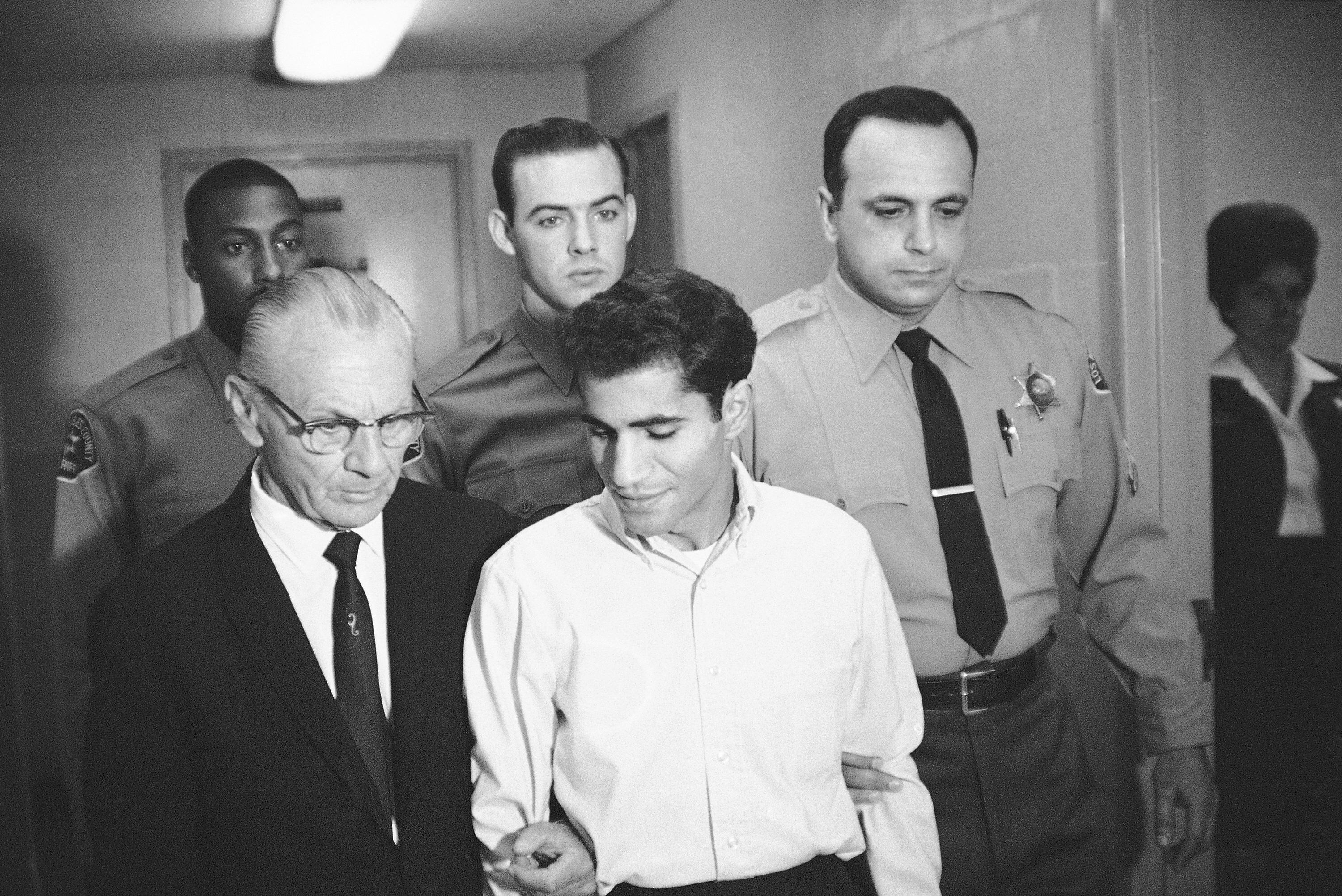 ARCHIVO - En esta fotografía de archivo del 28 de junio de 1968, Sirhan Bishara Sirhan es escoltado por su abogado, Russell E. Parsons desde la capilla de la cárcel del condado de Los Ángeles para declararse culpable de asesinato en Los Ángeles. (AP Photo/George Brich, File)