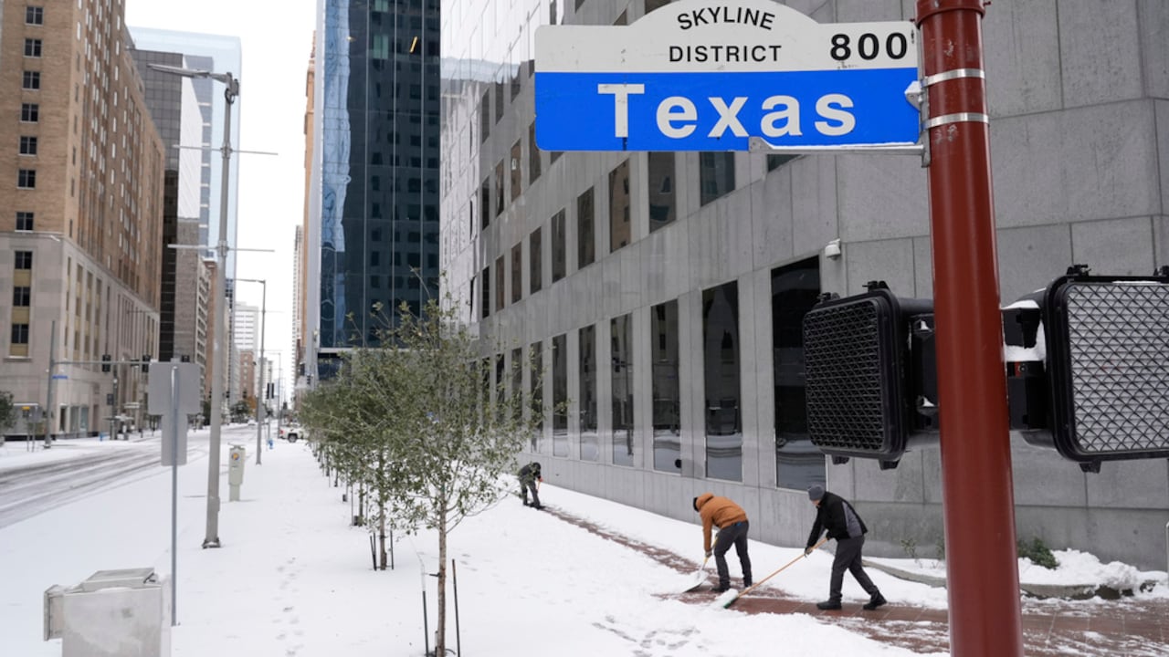 La gente quita la nieve de la acera con una pala el martes 21 de enero de 2025 en el centro de Houston. (Foto AP/Ashley Landis)