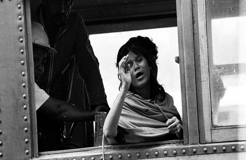 En una chiva dos integrantes de la Defensa Civil trasladan a una mujer víctima del desastre natural, quien trataba de explicar a gritos que todo estaba destruido.