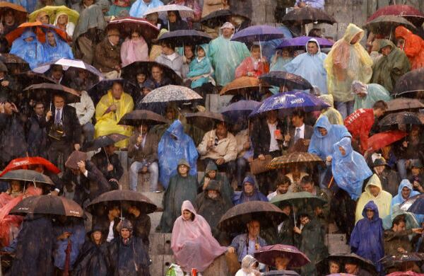 Los asistentes al sexto festejo de la Feria de San Isidro se protegen de la lluvia registrada en durante las corridas de toros en Madrid, España. (EFE)