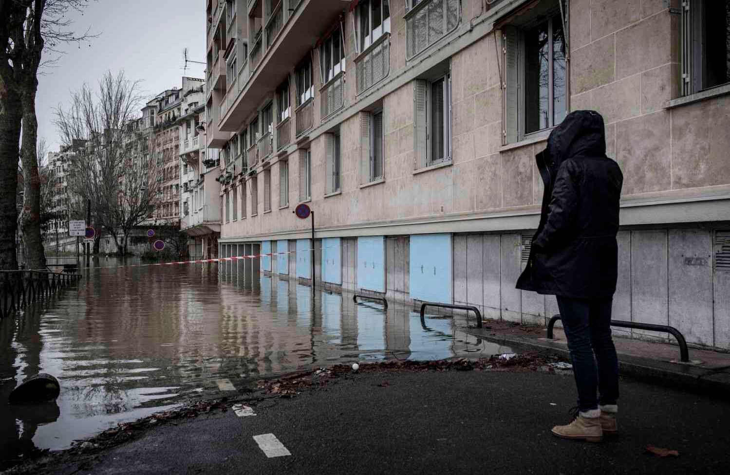 Una mujer mira una calle inundada cerca del río Sena en París el 25 de enero de 2018.  El Sena siguió en aumento el 25 de enero de 2018, inundando las calles y colocando a los museos en una situación de emergencia a medida que las precipitaciones récord empujaban a los ríos sobre sus orillas en el noreste de Francia. / AFP PHOTO / Philippe Lopez.
