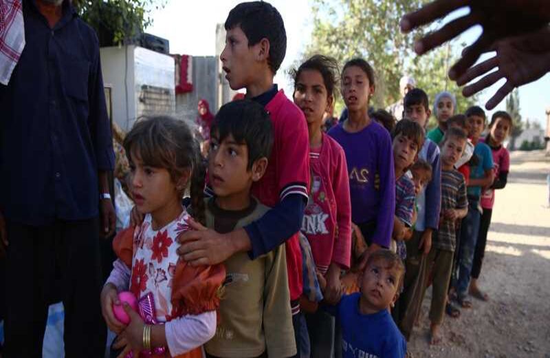 Niños que huyeron con sus familias hacen fila para recibir la ayuda de una ONG. 13 de agosto del 2016. Foto AFP.