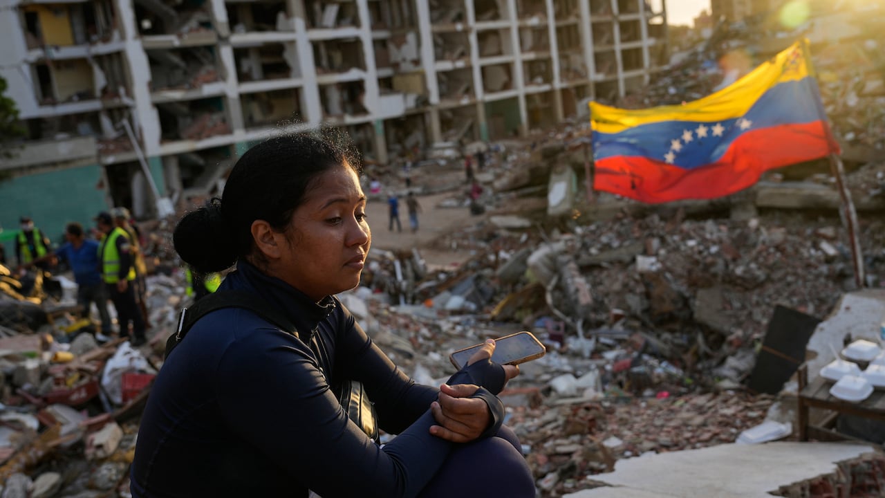 Estefany Landaez permanece sentada entre los escombros de un edificio esperando encontrar a sus dos hijos tras los terremotos en La Guaira, Venezuela. (AP Foto/Ariana Cubillos)