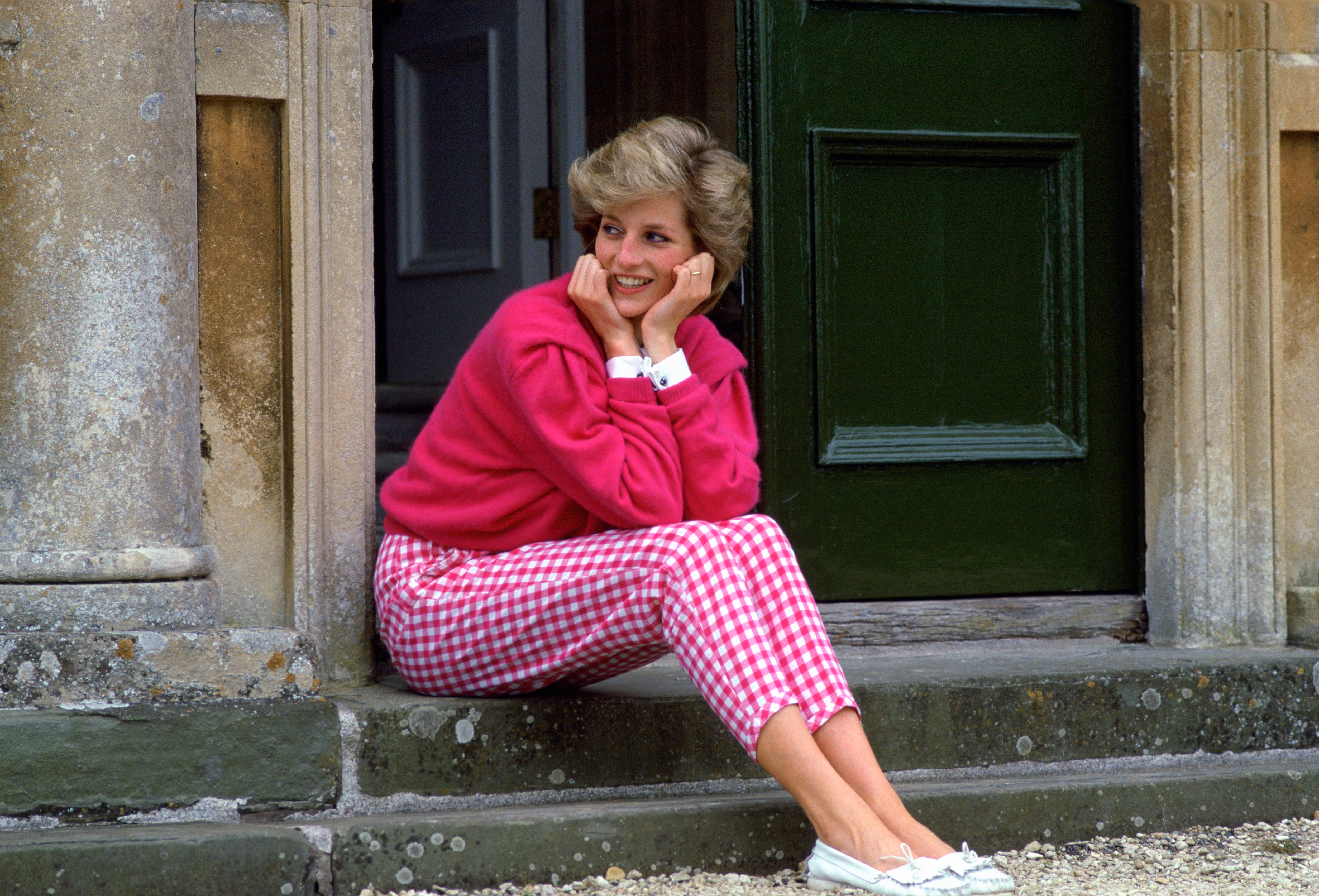 HIGHGROVE, UNITED KINGDOM - JULY 18:  Diana, Princess Of Wales, Sitting On The Steps Outside Her Country Home, Highgrove.  The Princess Is Casually Dressed In Pink Gingham Trousers With A Matching Pink Jumper.  (Photo by Tim Graham Photo Library via Getty Images)