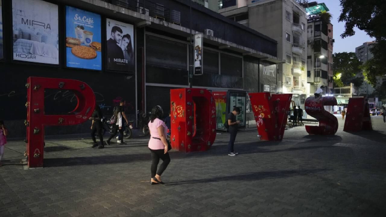 Los peatones pasan frente a un letrero de PDVSA (Petróleos de Venezuela, SA) en el bulevar Sabana Grande, en Caracas, Venezuela, el 20 de marzo de 2023