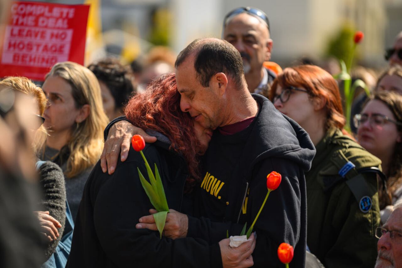 TEL AVIV, ISRAEL - FEBRUARY 26: A crowd watches a live feed from a funeral for members of the Bibas family on a screen in what's known as Hostages Square on February 26, 2025 in Tel Aviv, Israel. A funeral is being held for former hostages Shiri Bibas and her two young sons, Ariel and Kfir, whose bodies were returned to Israel from Gaza last week. At the time of their abduction from Kibbutz Nir Oz on October 7, 2023, Shiri was 32, Ariel was four, and Kfir was nine months old. Their father, Yarden Bibas, 34, was also taken by Hamas militants, but was released alive as part of the ceasefire agreement on 1 February. (Photo by Alexi J. Rosenfeld/Getty Images)