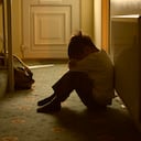 sad child with his head between his legs left alone at home