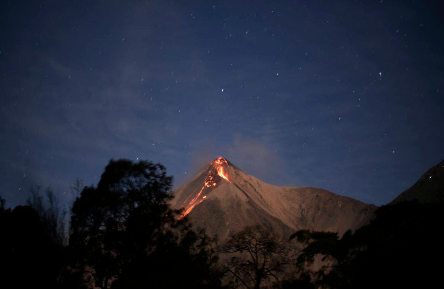 El volcán Fuego arroja ceniza, como se ve desde la ciudad de Alotenango en el departamento de Sacatepéquez, a 65 km al sureste de Ciudad de Guatemala, el 1 de febrero de 2018. El volcán de Fuego, ubicado a 35 kilómetros al sureste de la capital guatemalteca, aumentó su actividad eruptiva, arrojando cenizas que alcanzaron varias aldeas, informó la protección civil. / AFP PHOTO / JOHAN ORDONEZ.