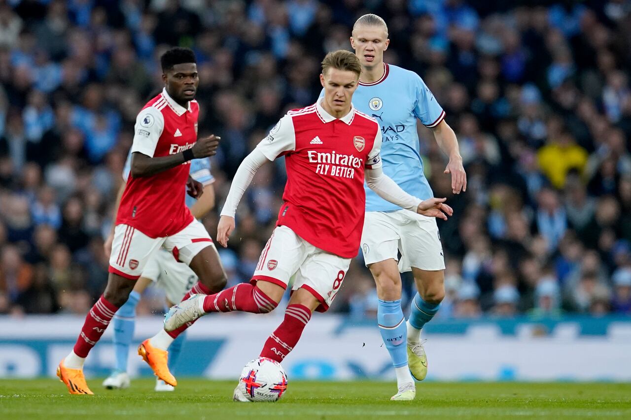 Arsenal's Martin Odegaard controls the ball next to Manchester City's Erling Haaland, right, during the English Premier League soccer match between Manchester City and Arsenal at Etihad stadium in Manchester, England, Wednesday, April 26, 2023. (AP Photo/Dave Thompson)