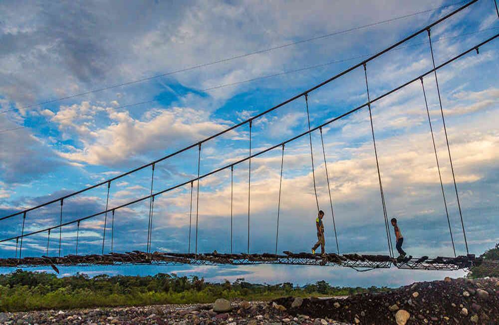 Niños de Cumaral, Meta, cruzan el puente colgante sobre el río Guatiquía.