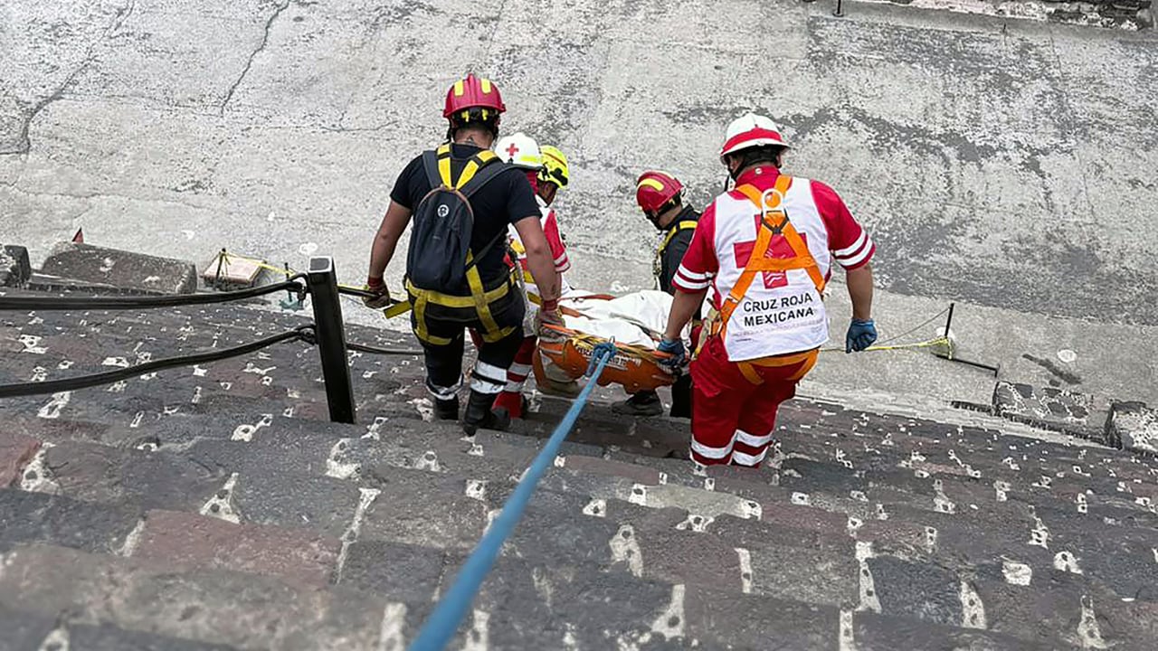 Esta imagen publicada por la Cruz Roja Mexicana muestra a expertos forenses y personal de la Cruz Roja transportando un cuerpo en la Pirámide de la Luna, en la zona arqueológica de Teotihuacán, el 20 de abril de 2026.