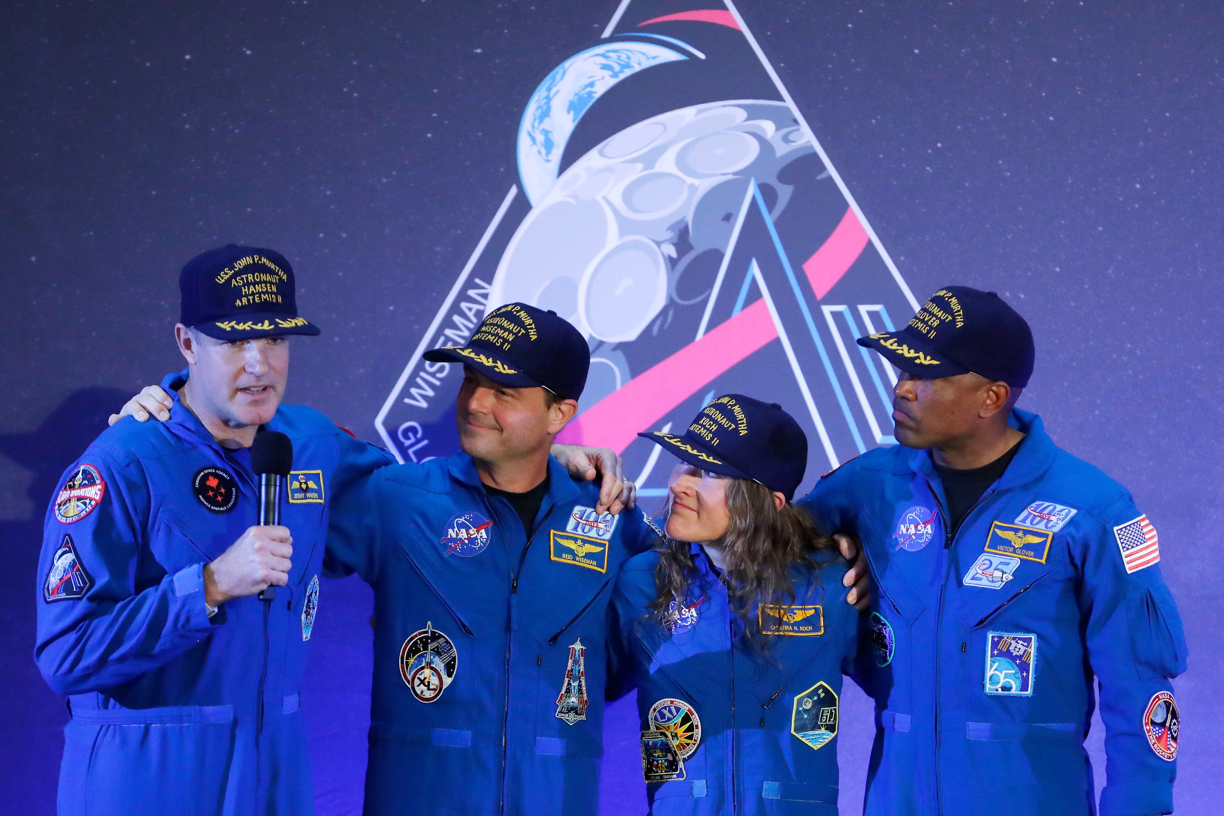 La tripulación del Artemis II, de izquierda a derecha: Jeremy Hansen, Reid Wiseman, Christina Koch y Victor Glover, se reúnen con Hansen mientras este pronuncia un discurso durante un acto de bienvenida a la tripulación en el aeropuerto Ellington Field de Houston.
