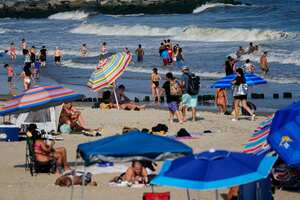 FILE - People enjoy the water at Rockaway Beach, Tuesday, July 19, 2022, in the Queens borough of New York. Authorities say a woman was critically injured when a shark bit her on the leg Monday, Aug. 7, 2023, while she was swimming at Rockaway beach. (AP Photo/Frank Franklin II, File)