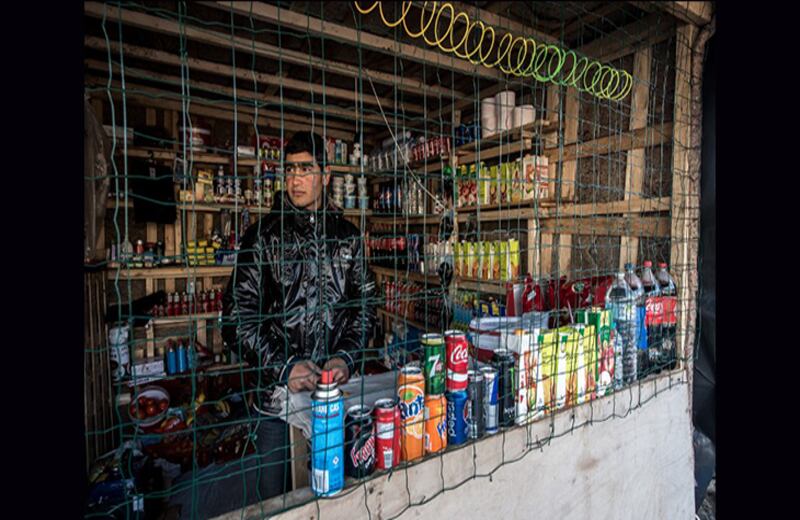 Un inmigrante afgano de Kabul maneja una improvisada tienda. Foto: Philippe Huguen / AFP
